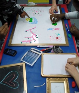 Figure 1. Participants collaborating on frames using mixed media during “Open Air Art” lesson