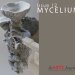 Clay sculpture of mycelium on the edge of a beige plastic bin.